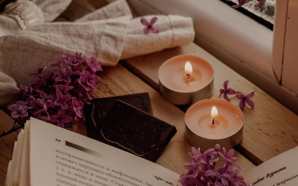 A calm and serene setting with book and small lighted candles.